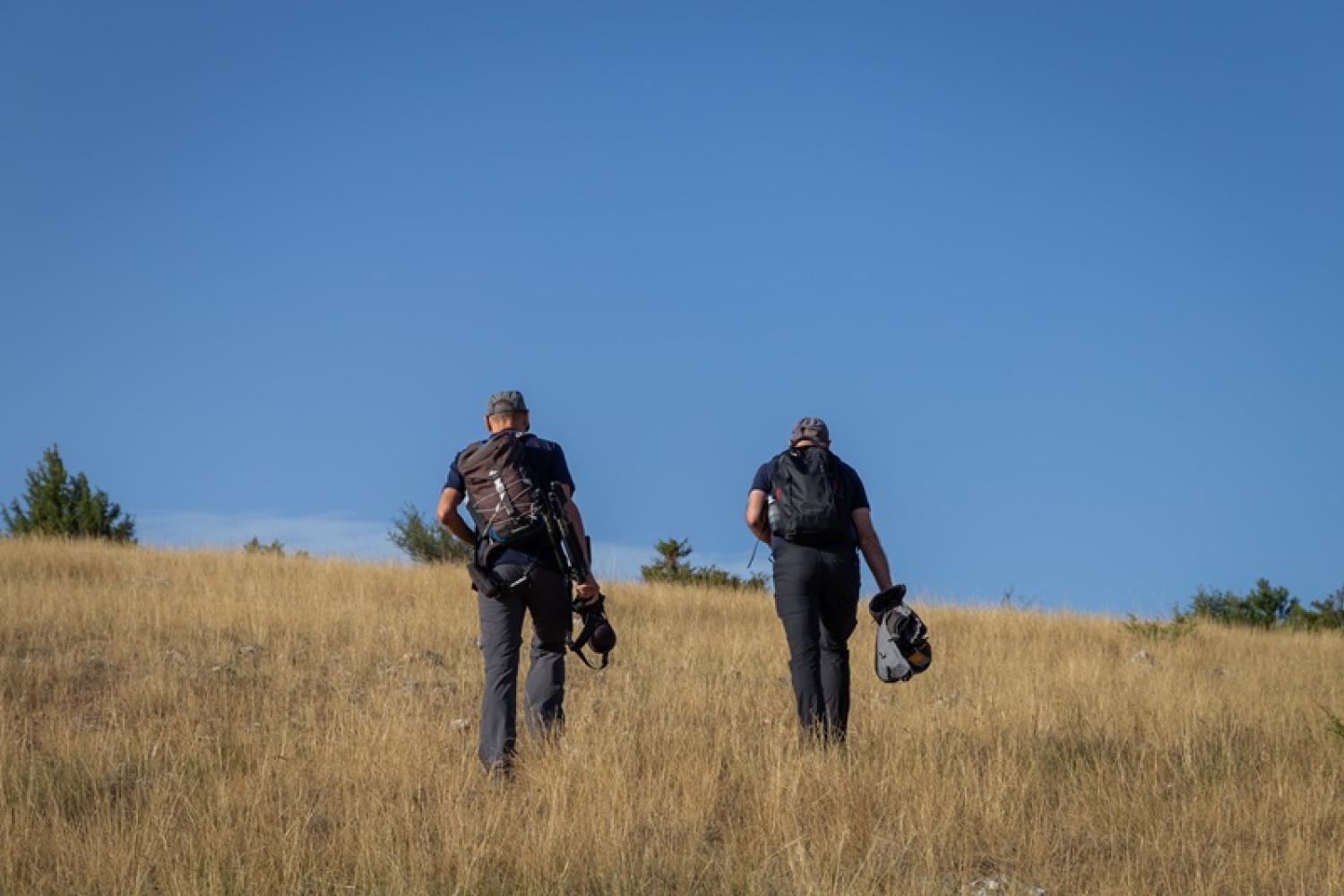 deux agents marchent sur le causse méjean